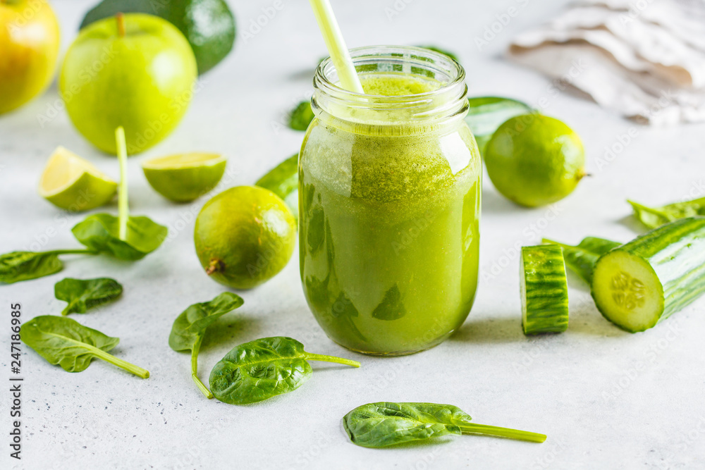 Green healthy smoothie (juice) in the jar. Apple, spinach, cucumber smoothie on white background with the ingredients.