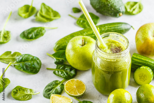 Green healthy smoothie (juice) in the jar. Apple, spinach, cucumber smoothie on white background with the ingredients.