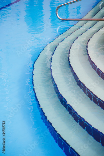Blue tile covered steps leading down to a swimming pool