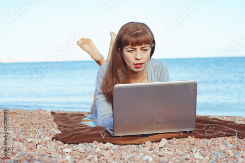 girl with laptop on the beach