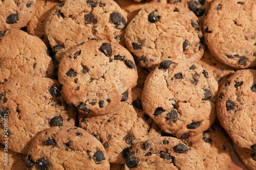 Tasty chocolate chip cookies as background, top view