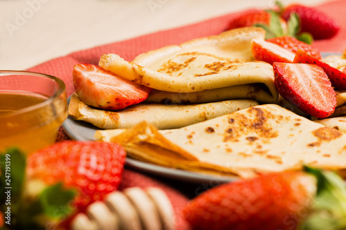 Fresh homemade crepes with strawberry and honey
