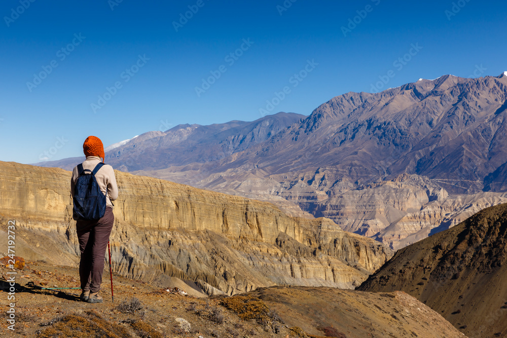 girl with a backpack looks at the mountains, Nepal. Tourist girl stands back.