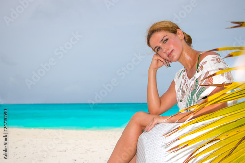 Young woman sitting on sofa at the beach