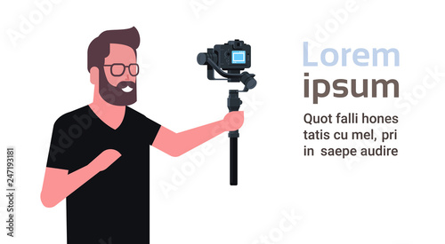 man blogger broadcasting live stream report shooting selfie video guy in front of DSRL camera recording himself using motorized gimbal stabilizer social media concept copy space horizontal