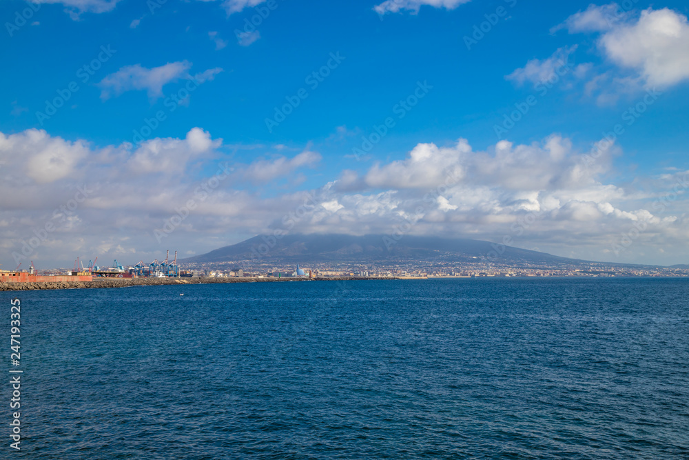 Port of city of Naples with Vesuvius vulcan in background with cloudy blue sky, Napoli Italy