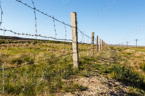 fence of barbed wire that separates the railway from the steppe, Mongolia