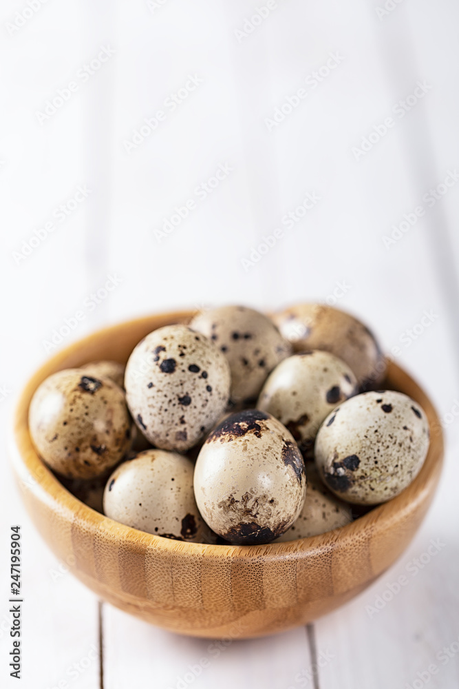 quail eggs in wooden plate over white background quail eggs in wooden plate over white background