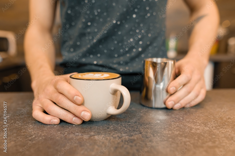Close up of baristas hands and freshly prepared art coffee with foam and pattern Close up of baristas hands and freshly prepared art coffee with foam and pattern
