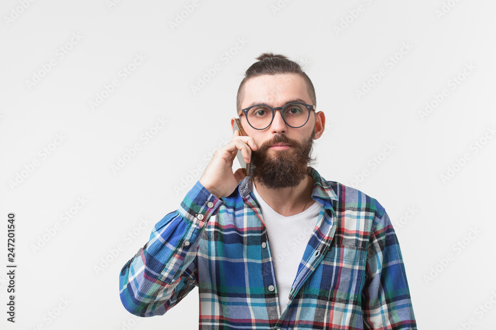 Technologies, communication and people concept - Cool man with beard talking on mobile phone over white background Technologies, communication and people concept - Cool man with beard talking on mobile phone over white background