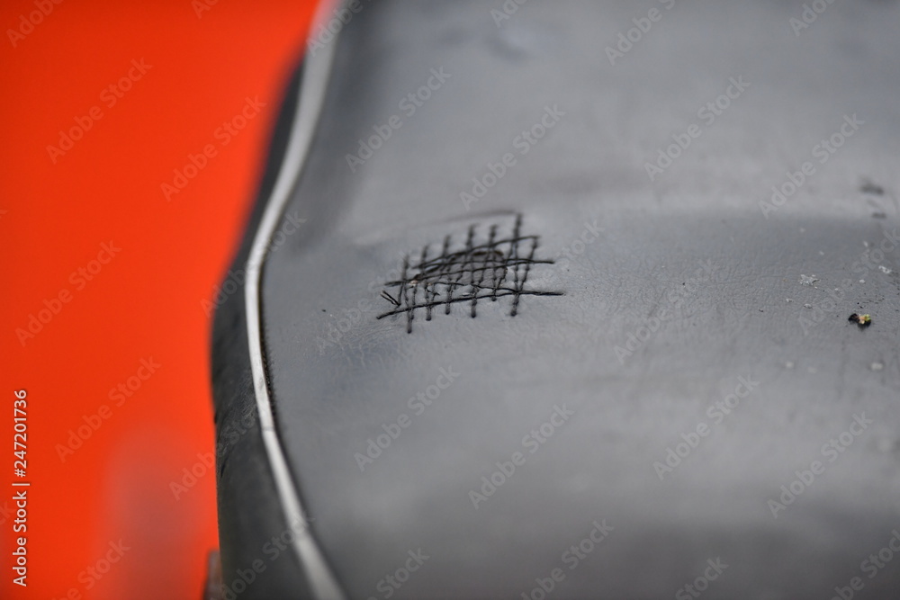 Partial view of an old, patched black motorcycle bench. Partial view of an old, patched black motorcycle bench.