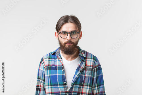 Beauty, fashion and people concept - Portrait of a young bearded hipster stylish guy over white background. © satura_