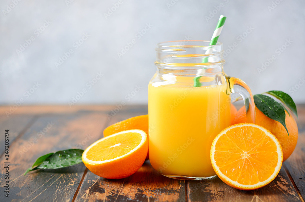 Fresh orange juice in a jar on gray concrete background. Fresh orange juice in a jar on gray concrete background.
