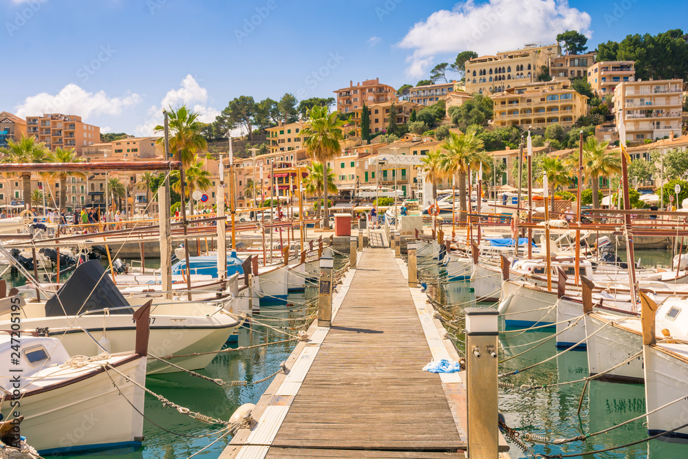 Beautiful Port de Soller in Mallorca full of motor boats and buildings on cliffs