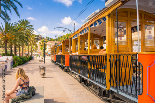 Famous old train in Port de Soller in Mallorca full of motor boats and buildings on cliffs