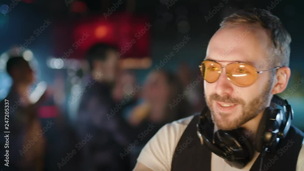 DJ is playing music at a party in a nightclub DJ is playing music at a party in a nightclub