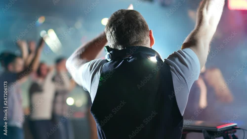 DJ is playing music for dancing people in the night club DJ is playing music for dancing people in the night club