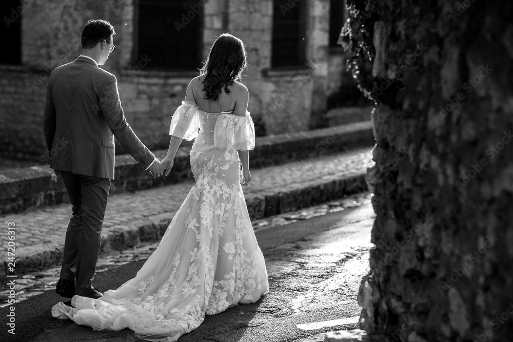 Black and white photo of beautiful young newlyweds that strolling on the street of the old town. Wedding day Black and white photo of beautiful young newlyweds that strolling on the street of the old town. Wedding day
