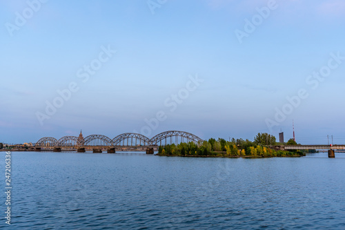 View of Cityscape with Railway Bridge in Riga, Latvia, on Blue Hour, Twilight with a Free Space for Text, Concept of Travels © Reinholds