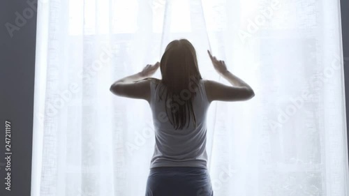 Happy woman getting up from bed in the morning photo