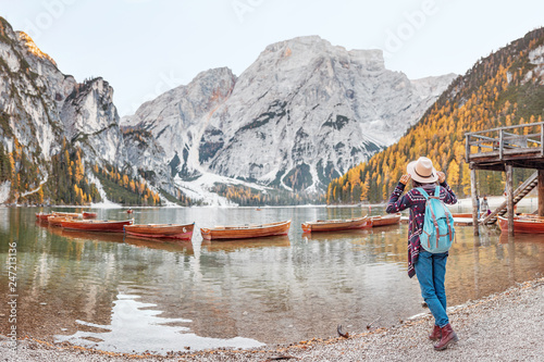 Asian girl traveler at the majestic Braies lake in South Tyrol, Italy. Vacation and adventure outdoors in nature park concept
