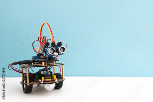 Hand made robot working on the arduino platform. White background. Free space for text. STEM education for children and teenagers, robotics and electronics. DIY. AI. STEAM.