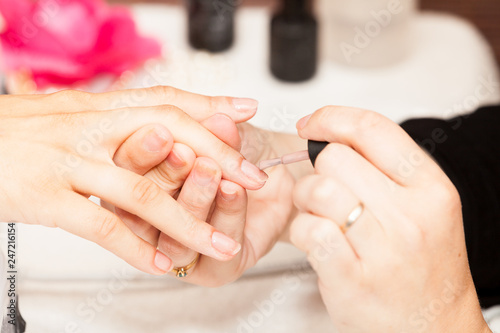 Applying nail polish on a woman s hands