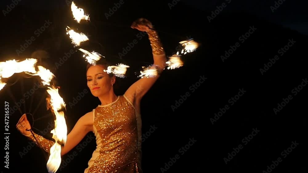Amazing art action at open air. Attractive girl model juggling igniting sparkling torches slowmotion. Actress entertaining tourists, twilight spectacle in amphitheater. Program in all inclusive tour