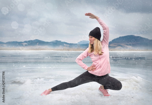 Running woman. Runner is jogging in winter day. Female fitness training outdoors photo