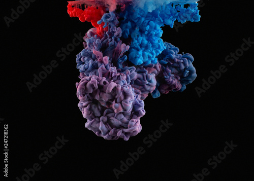 Swirling colorful drops cloud. Color splashes of ink isolated on black background. Abstract paint in water