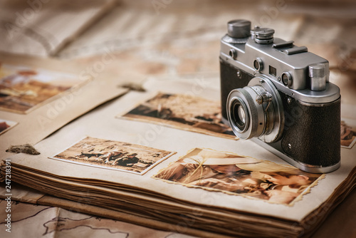Photo album with a camera on the background of old vintage maps