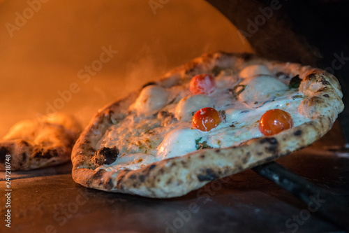 Cooking a delicious pizza in a wood oven, italian recipe