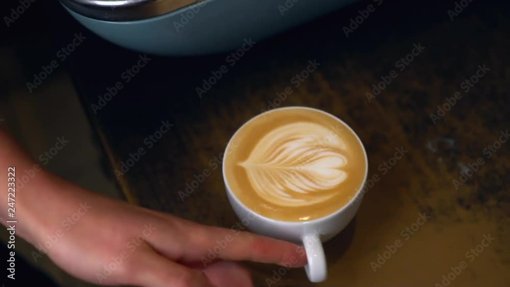 Barista makes coffee Latte with a heart shape in the foam for Valentines Day.