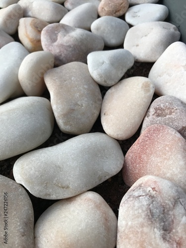 Natural rounded small white stones texture or background close-up
