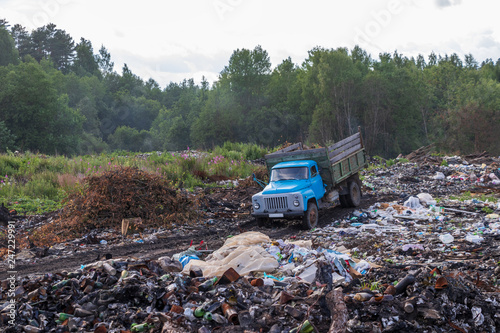 Old garbage truck rides on illegal garbage dump in the woods