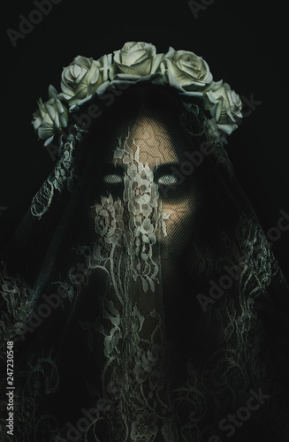 Creepy corpse zombie bride with white empty eyes on black background