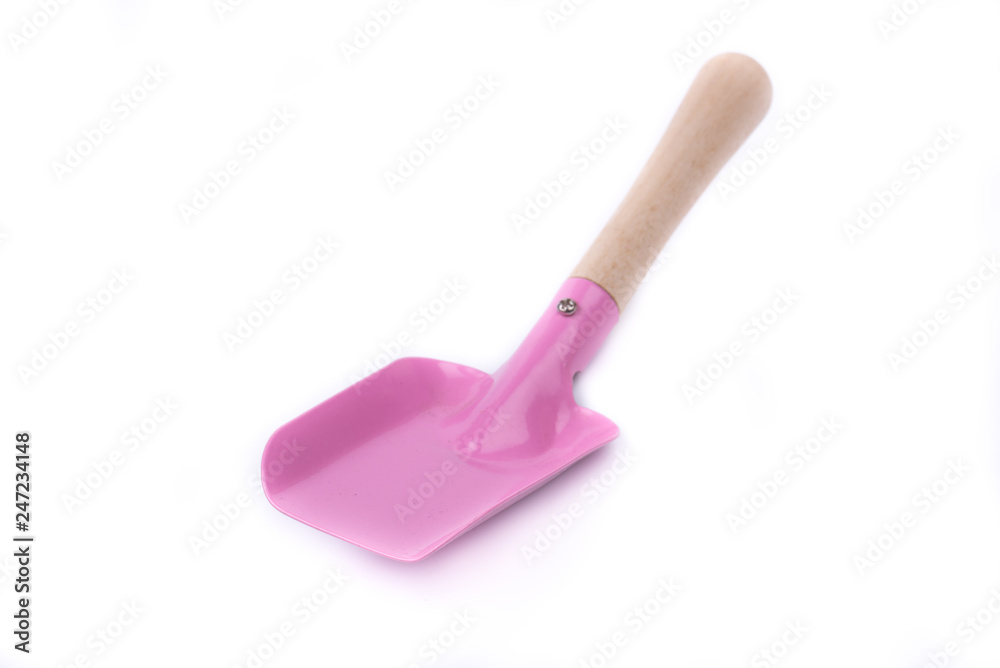Metal/iron childrens shovel with a wooden handle on a white background isolated close-up. New garden tool. Children wooden/metal toy. Garden equipment. Pink color. Front, side view. Overturned.