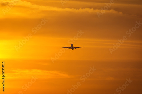 Small plane in the middle of the red clouds at sunset