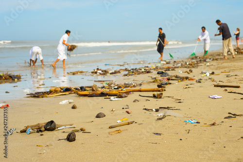 people cleaning ocean beach plastic