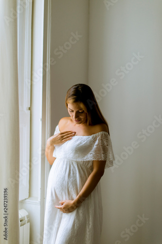 Young pregnant woman standi...