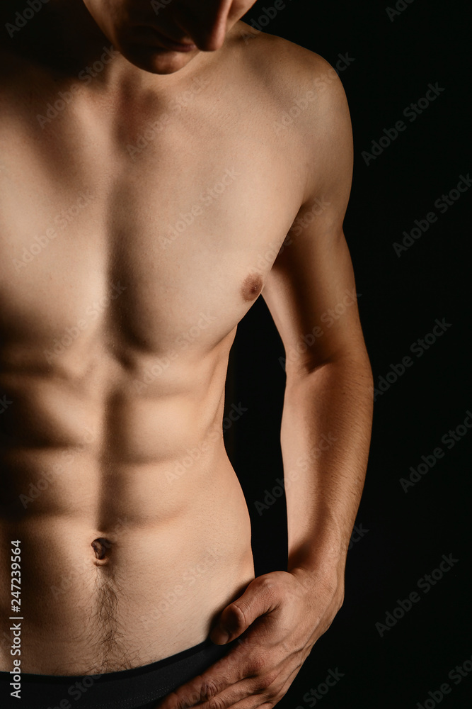 pumped handsome male press. Male athletic body closeup on black background. pumped handsome male press. Male athletic body closeup on black background.