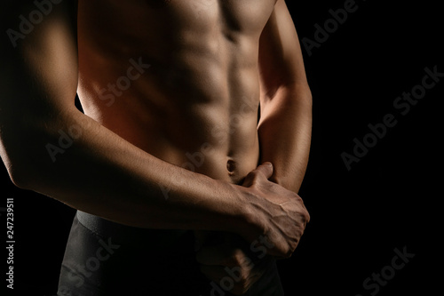closeup strong male hands and pumped up press. sportman's portrait in a low key