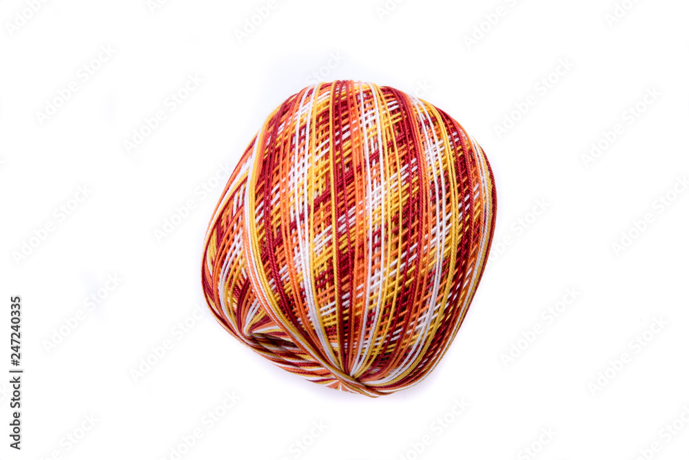 Fototapeta premium Ball of yarn. Thread for crochet and knitting works. Colorful - yellow, orange, red yarn ball. For handwork, leisure, hobby concept. Isolated on white background. Side view.