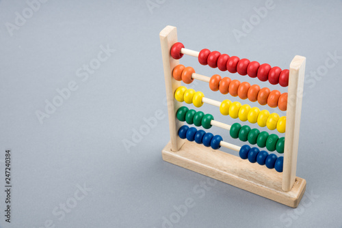 Traditional counts abacus with colorful wooden beads on gray background. Toy abacus to learn counting. Colorful children counting frame for kids. Counts show  one  two  three  four  five.