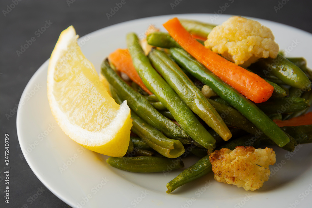 Vegetarian food. Cooked tir, green beans with carrots and lemon, on white plate. Famous Chinese cuisine. Healthy food. Vegetarian food. Cooked tir, green beans with carrots and lemon, on white plate. Famous Chinese cuisine. Healthy food.