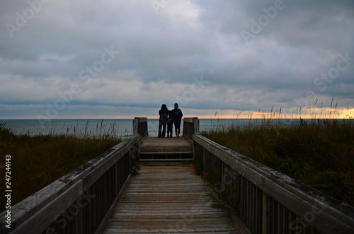 A family watches a sunrise at the beach