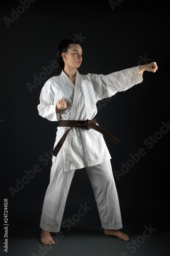 Young woman dressed in traditional kimono practicing her karate moves