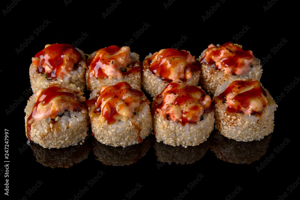 Hot fried Sushi Roll with eel, smoked salmon, cheese and avocado on black background. Sushi menu. Japanese food. Hot fried Sushi Roll with eel, smoked salmon, cheese and avocado on black background. Sushi menu. Japanese food.