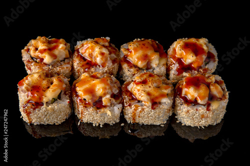 Hot fried Sushi Roll with smoked eel, shrimp, cheese and avocado on black background. Sushi menu. Japanese food. 