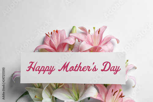 Fototapeta Naklejka Na Ścianę i Meble -  Composition with beautiful blooming lily flowers and card on white background